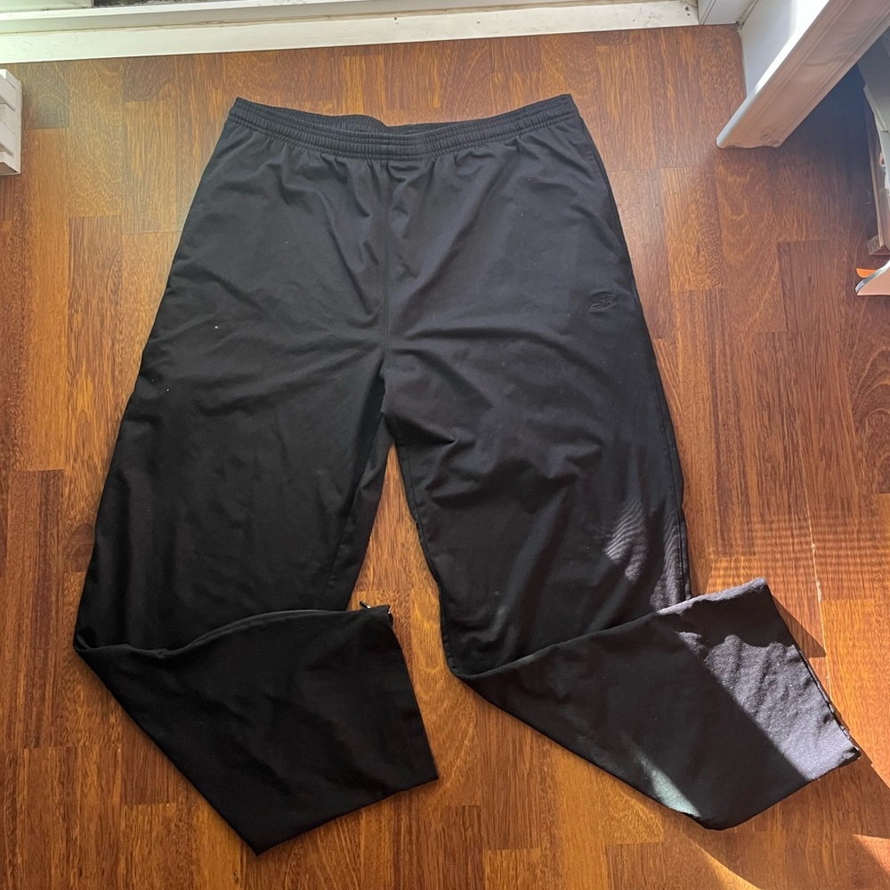 Men’s black wide legged sweat pants. With open zippers at the bottom.